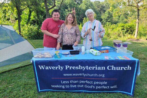 Three people outside at booth for event
