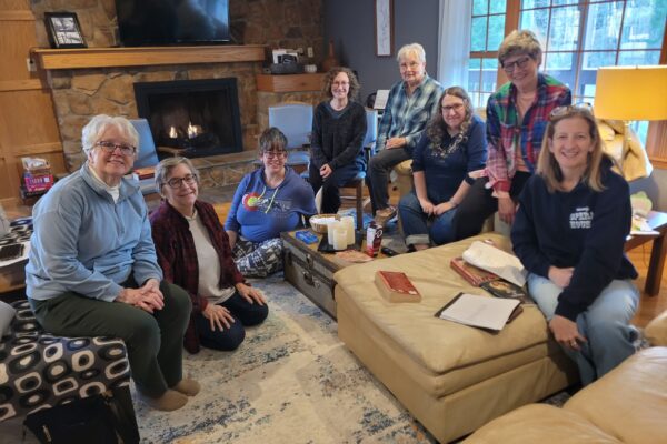group of women posing and smiling at cabin